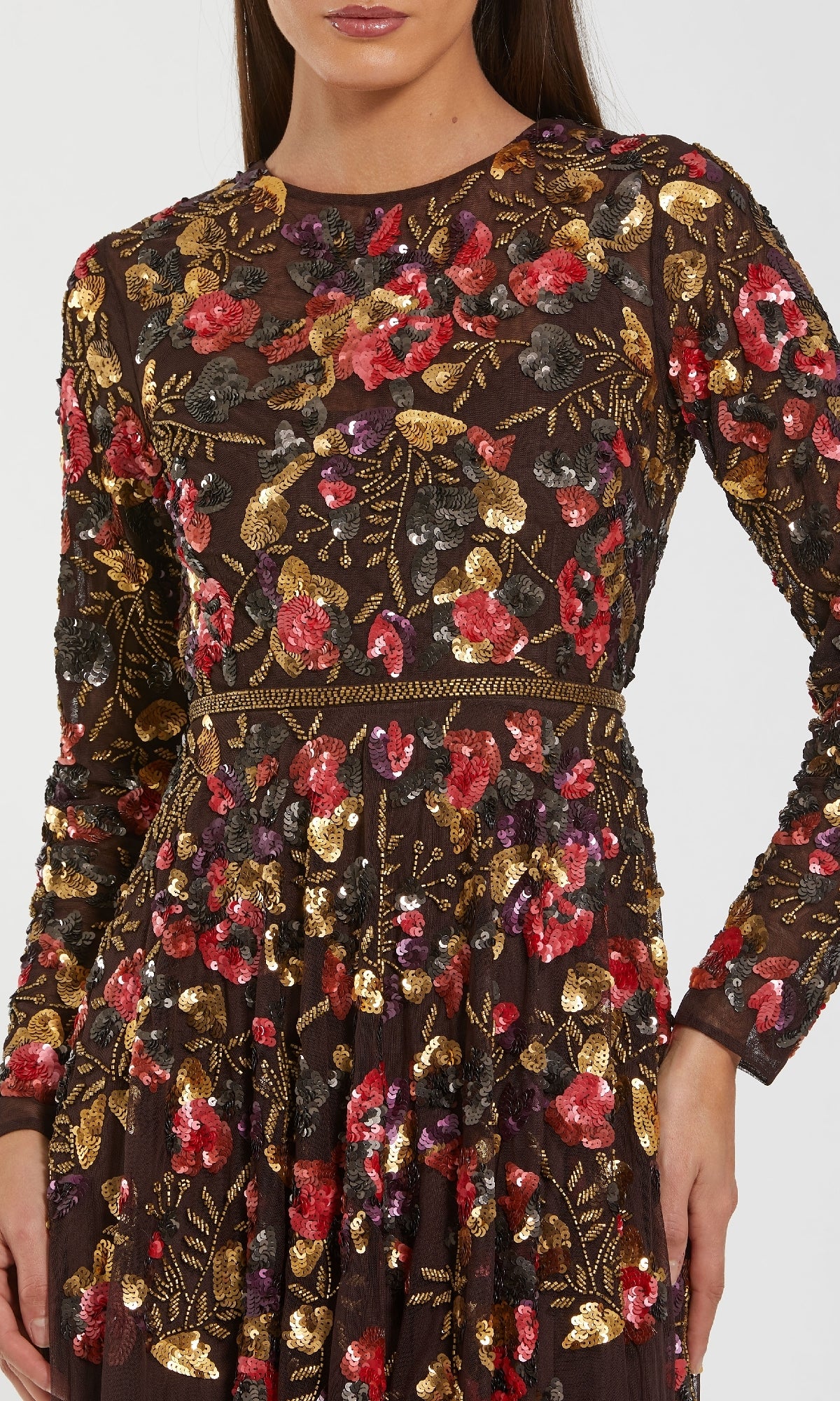 A woman wears the Mac Duggal 94275 long sleeve sequin formal dress, featuring red, gold, and pink floral embroidery with sequins on dark mesh—an elegant choice for a mother of the bride.